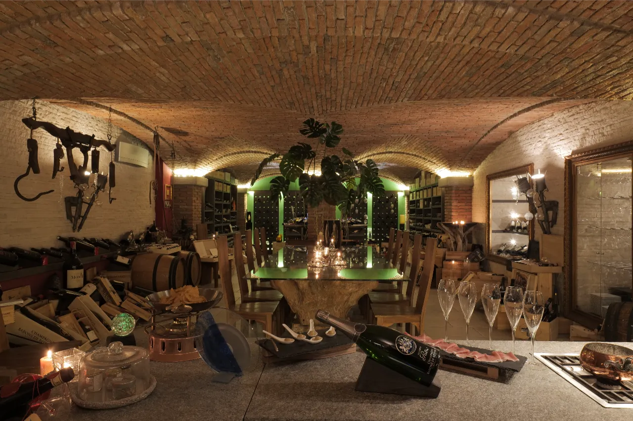 Bespoke private tasting room featuring groin vaults with unique lowered raised arches. The exposed brick masonry integrates with custom furniture for a refined and intimate wine experience near Como.