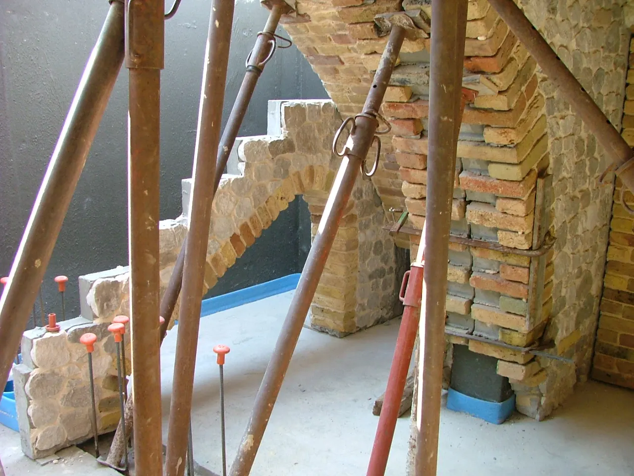 Installing the large brick arch to the staircase, with the shoring still in place — Flumignano basement tavern