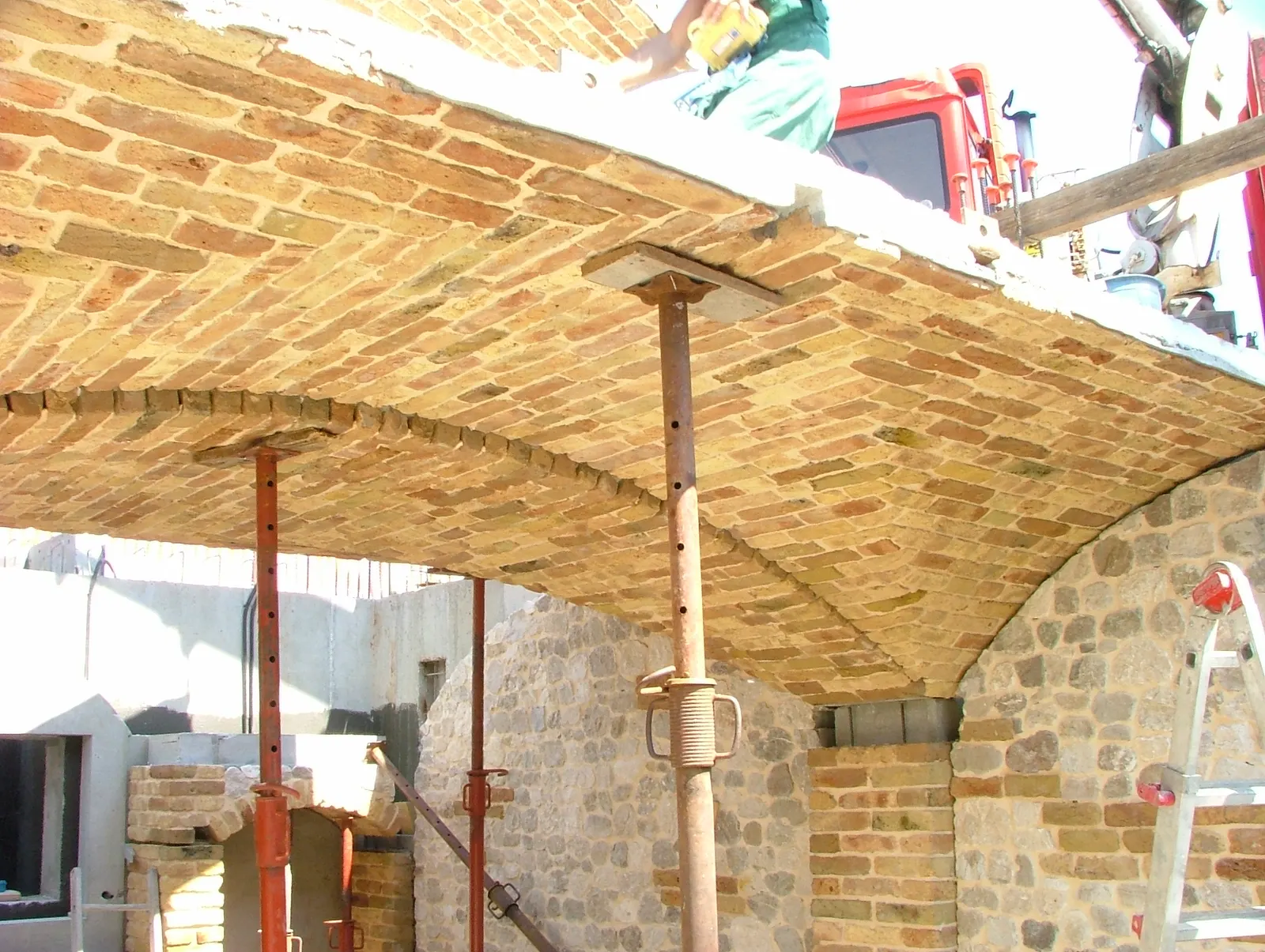 Groin vault panels in brick shored up on top of the stone walls during installation — Flumignano, Italy