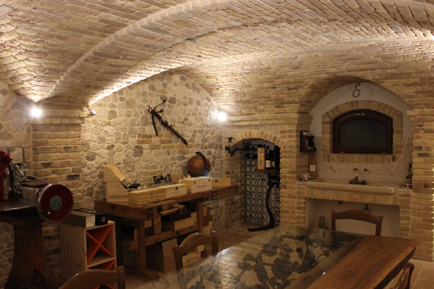 Taverna old world con soffitto a volta in mattoni, pareti in pietra naturale e nicchie per il vino — casa privata, Udine, realizzata da Pietrantiche