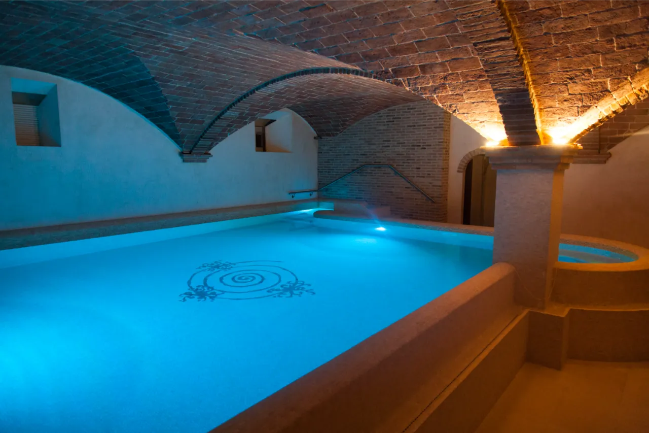 Bespoke brick cross vaulted ceiling designed for a luxury private indoor pool and spa. Flat-laid antique terracotta tiles create a continuous, elegant surface that softly reflects the lighting over the water.